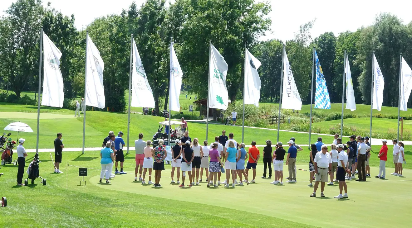 Zahlreiche Golf-Einsteiger versammeln sich auf dem Putting-Green