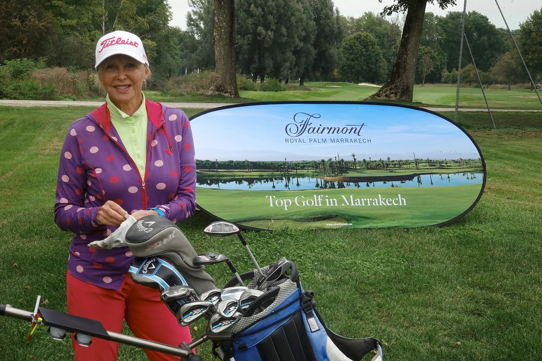 Chris Lang-Ruckhäberle farbenfreudig vor dem Schild des Turniersponsors, Hotel Fairmont Royal Palm Marrakech
