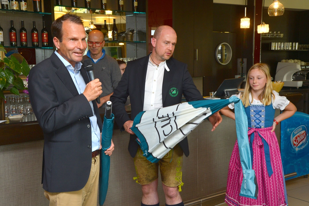 Geschäftsführer Wolfgang Michel bedankte sich bei Sponsor Kai Pierre Thieß für sein Engagement; daneben Chiara Aumann, versteckt dahinter Wirt Uli Sauer