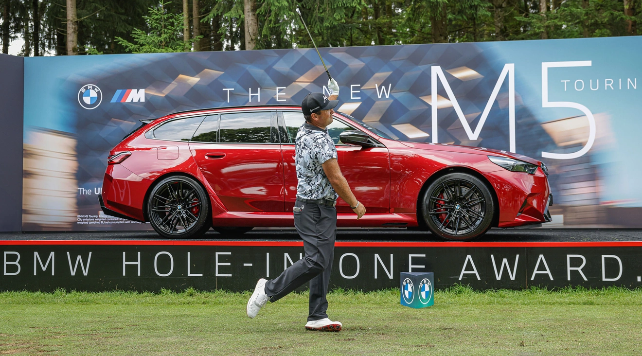 Abschlag Patrick Reed vor rotem BMW