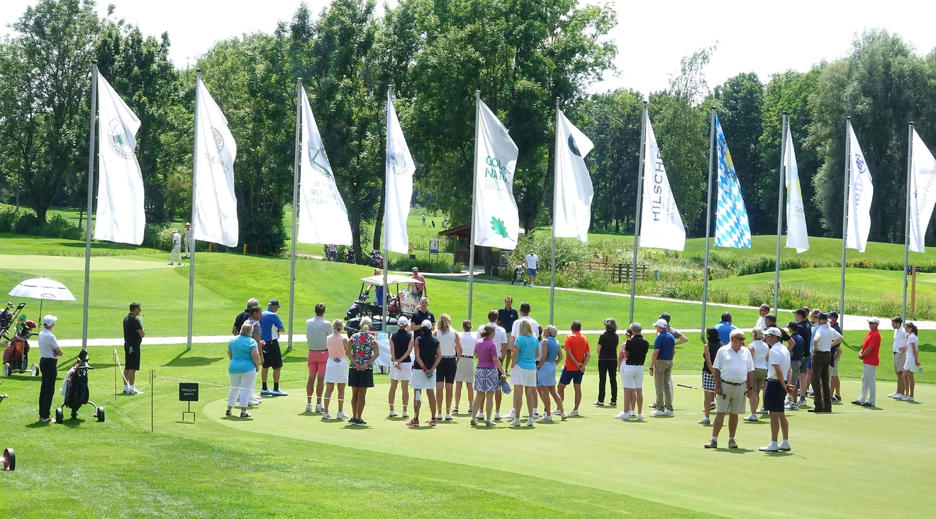 Zahlreiche Golf-Einsteiger versammeln sich auf dem Putting-Green