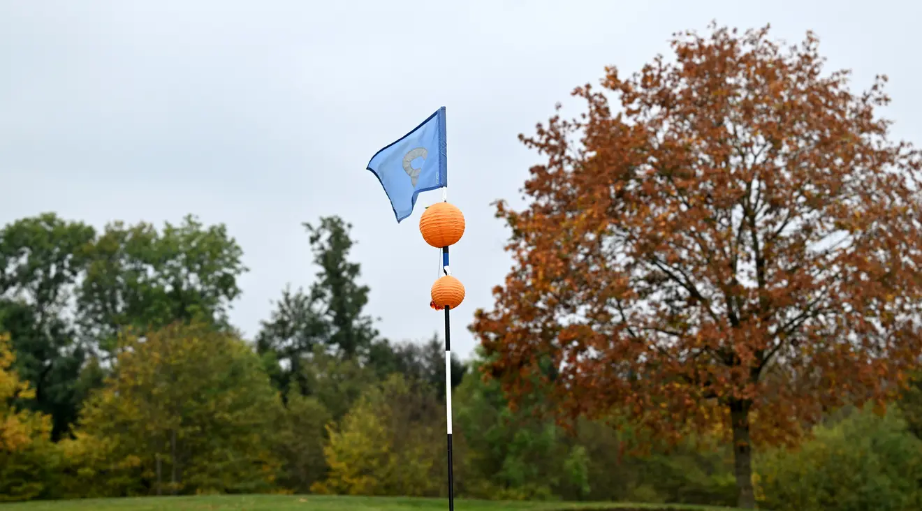 Fahnenstange mit orangenen Laternen