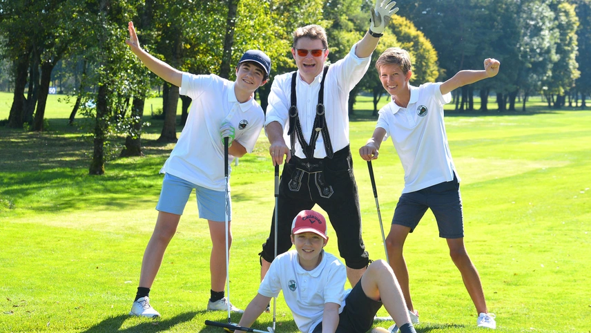 Vater mit 3 Kindern posiert an Golffahne