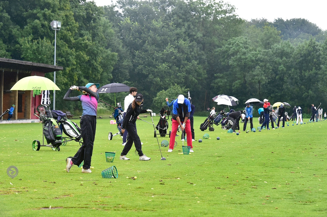 Vor dem Turnierstart wurde auf der Driving Range eifrig trainiert – noch mit Regenschirm und Regenanzug.