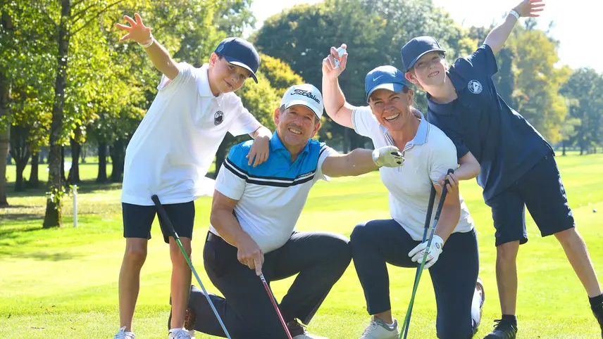 4-köpfige Familie posiert vor Golffahne