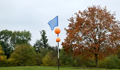 Fahnenstange mit orangenen Laternen