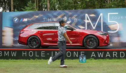 Abschlag Patrick Reed vor rotem BMW